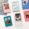 A collection of colorful magnetic photo frames displaying various small photographs.
