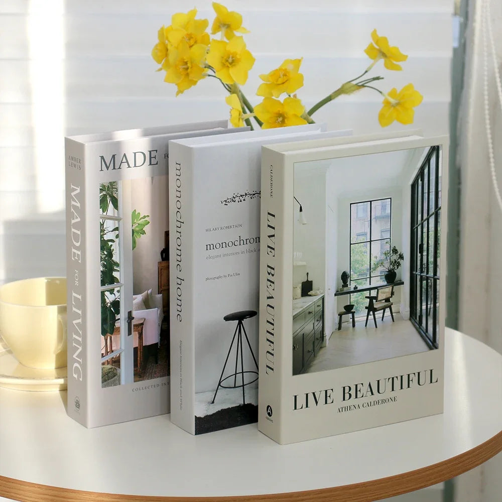 A set of three hardcover books with yellow floral accents displayed on a white table.