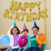 Three smiling children holding a large golden birthday banner and colorful balloons