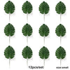 Twelve artificial tropical palm leaves in various shades of green displayed for party decor