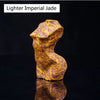 Una figura de jade imperial claro con vetas amarillas y moradas, exhibida contra un fondo oscuro.