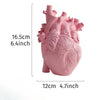 Pink heart-shaped resin sculpture of a human heart with visible arteries and veins