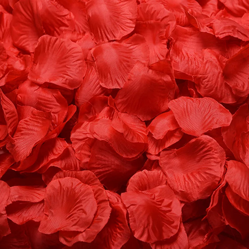 A close-up of vibrant red artificial silk rose petals scattered in a pile.