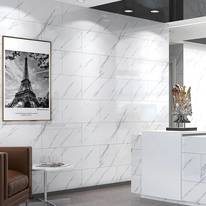 A modern interior wall featuring white marble tile patterns and a black ceiling, with a framed Eiffel Tower print on the left