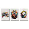 Three modern canvas wall art prints featuring vibrant paint splatters and gaming accessories like a controller, a hoodie, and