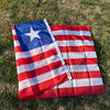 A decorative banner displaying the flag of Liberia, featuring red and white stripes and a blue field with a white star, laid 