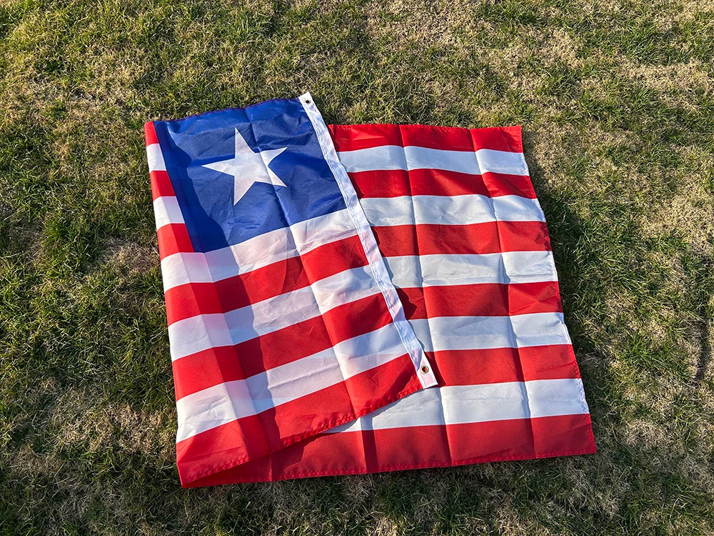 A decorative banner displaying the flag of Liberia, featuring red and white stripes and a blue field with a white star, laid 