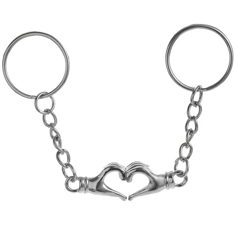 Clés en forme de cœur argentées pour couples, avec un délicat design de chaîne.