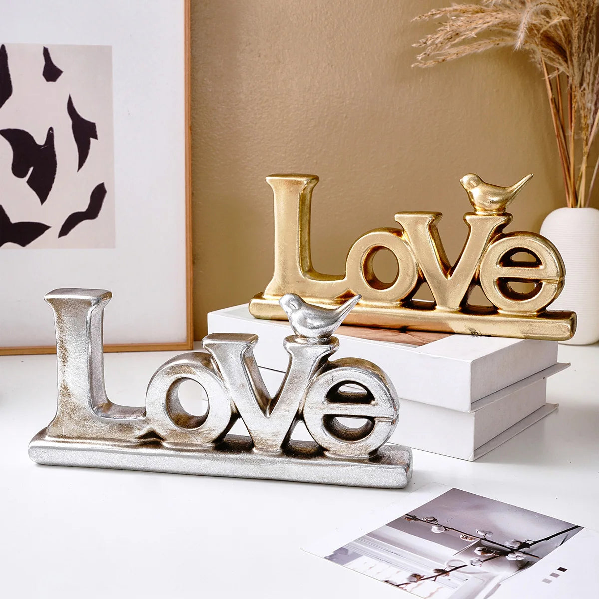 Retro gold and silver foil resin letters spelling LOVE displayed on a white surface.