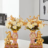 A pair of elegant ceramic vases shaped like swans with gold accents and floral arrangements.