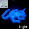 A glowing blue realistic Sphynx cat fidget toy shown in daytime and night contexts.