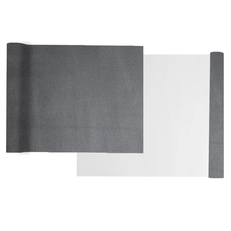 A roll of gray suede wrap fabric next to a sheet of white material for DIY projects.