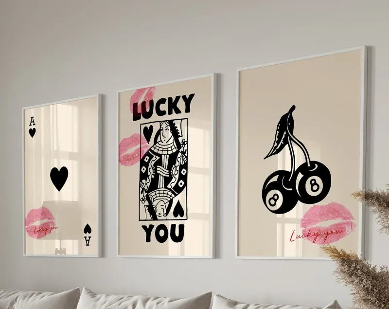 Three framed art prints featuring the text LUCKY YOU in various pink and black typography styles