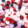 Gros plan de pétales de roses de soie artificielle dans diverses nuances de rose, rouge, violet et bleu.