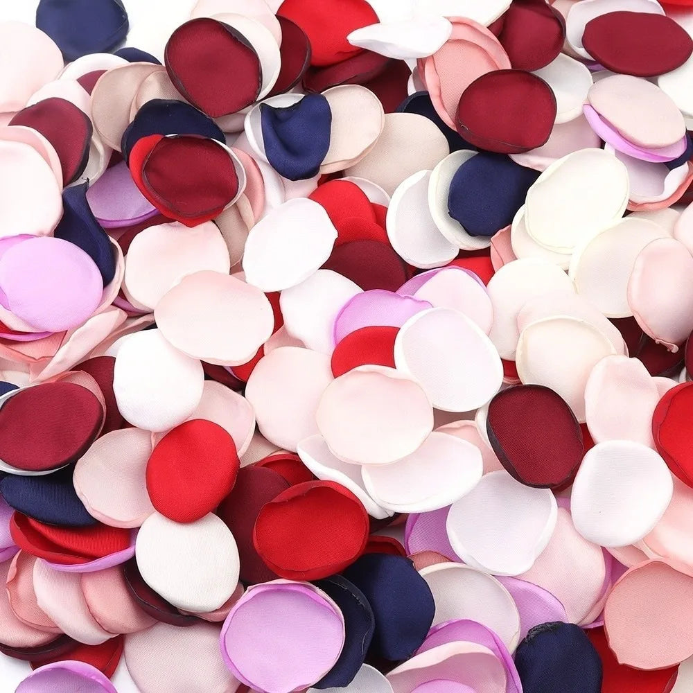 Gros plan de pétales de roses de soie artificielle dans diverses nuances de rose, rouge, violet et bleu.
