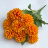 A bouquet of artificial orange flowers resembling hydrangea and camellia blooms with green leaves.