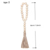 A beige wooden bead necklace with a long tassel, used as a type 2 wall hanging.
