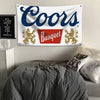 Ein weißes Banner mit blauem Text, das "Coors Banquet" zeigt, über einem grauen Bett