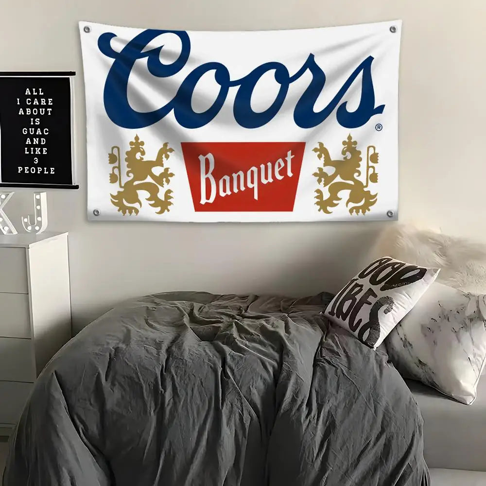 Ein weißes Banner mit blauem Text, das "Coors Banquet" zeigt, über einem grauen Bett.