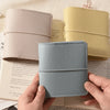A close-up of a light blue faux leather photo album next to two beige and pink leather-bound covers.