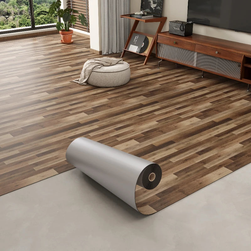 Roll of 3D textured wood grain self-adhesive flooring film laid on a light gray floor.