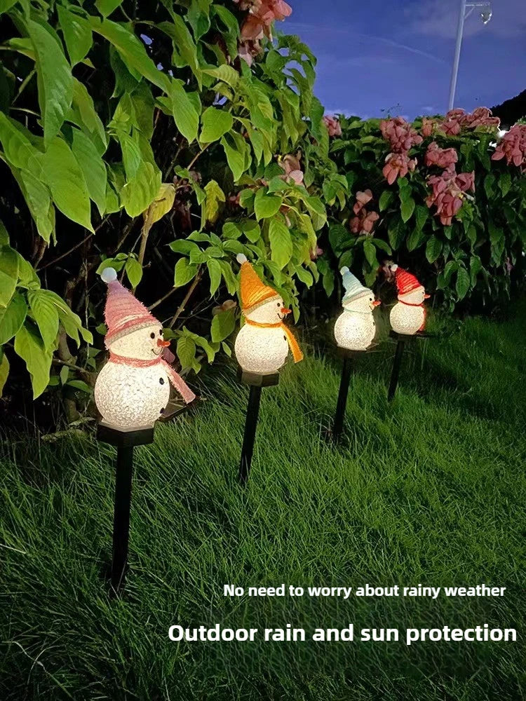 Outdoor decoration featuring several white snowman lights in a garden setting for rain and sun protection