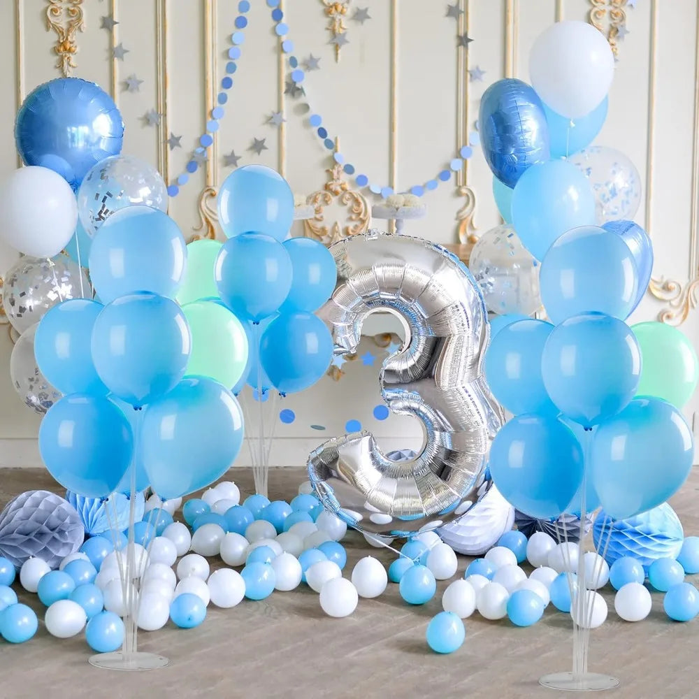 Une décoration de ballons bleus et argentés sur une table avec des éléments décoratifs dorés.
