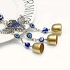 Carillon à vent argent et or avec perles en forme d'œil bleu et charms d'ailes déployées