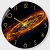 A round clock face displaying a vibrant, swirling galaxy pattern with gold hour markers.