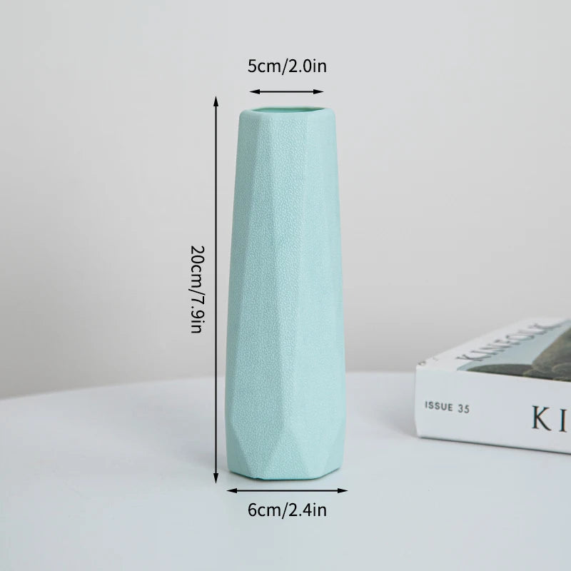 Eine hohe, hellmintgrüne moderne Plastikblumenvase, aufrecht stehend.