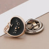 A pair of gold-toned pearl and rhinestone no-sew brooch buttons with Korean characters on a black background.