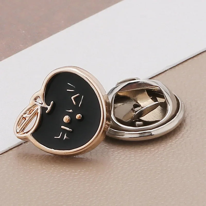 A pair of gold-toned pearl and rhinestone no-sew brooch buttons with Korean characters on a black background.
