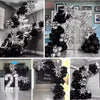 A collection of black and silver balloons arranged in various decorative arches and garlands for a birthday celebration.