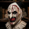 A close-up of a horror clown mask costume with white paint, red drips, and a black top hat.