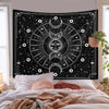 A black tapestry featuring a white psychedelic sun and moon mandala design hanging in a bedroom setting.