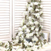 An artificial sakura flower garland draped across a white wooden window frame.