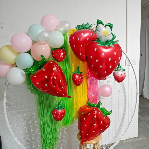 A colorful balloon decoration featuring strawberries, watermelon, and cherry shapes for a party.