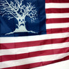 A decorative flag featuring a silhouette of a tree on a blue field and red and white stripes.