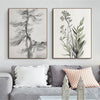 Two framed canvas prints featuring detailed black and gray botanical and forest line drawings displayed on a gray sofa.