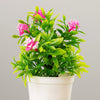 A vibrant artificial bonsai tree with bright pink and green leaves in a white pot.