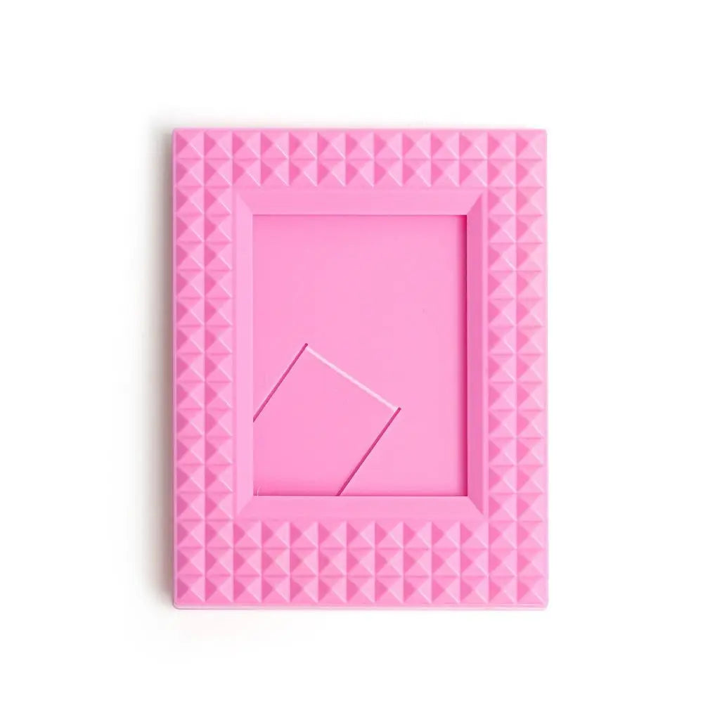 A pink mini film frame with a textured, diamond pattern for instant photos.