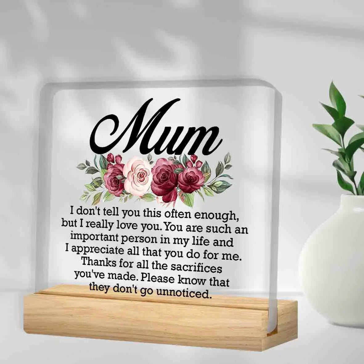 A personalized acrylic keepsake plaque with a wooden base featuring a floral design and a heartfelt message for Mom