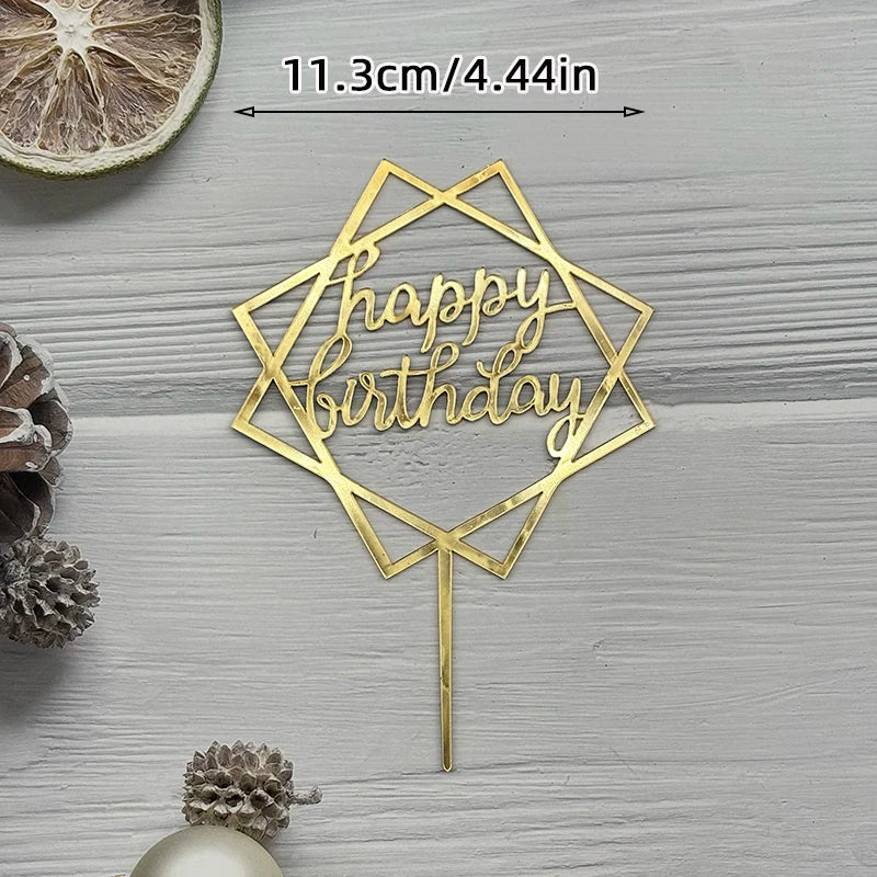 A gold acrylic cake topper shaped like a geometric star with the words Happy Birthday on a stick.