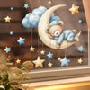 Autocollant murale ours en peluche phosphorescent avec une lune et des étoiles suspendues.