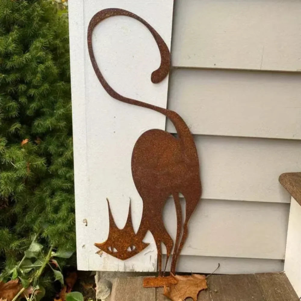 A rustic wrought iron cat ornament silhouette mounted on a white fence panel.