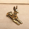 A vintage brass statue of a Pharaoh Hound dog, inspired by Egyptian motifs, resting on a neutral background.