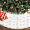 A plush faux fur Christmas tree skirt decorated with gold snowflakes and adorned with evergreen branches and ornaments.