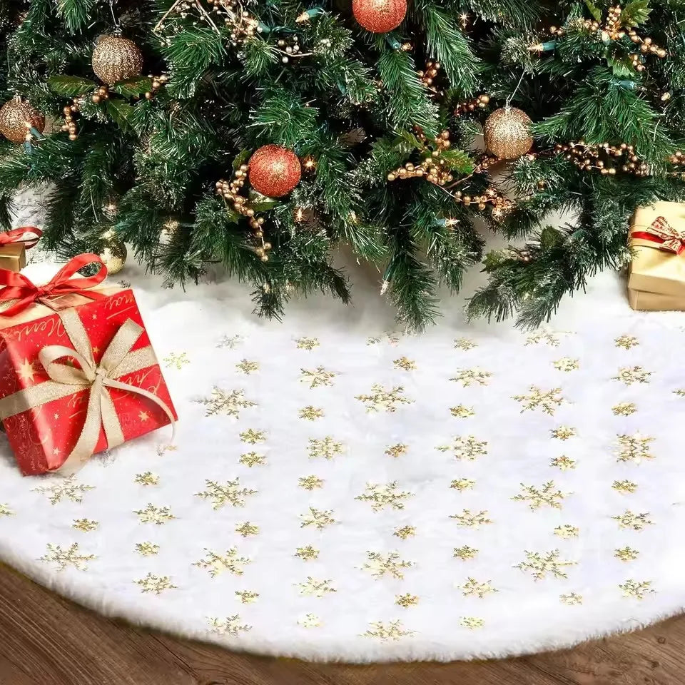 A plush faux fur Christmas tree skirt decorated with gold snowflakes and adorned with evergreen branches and ornaments.
