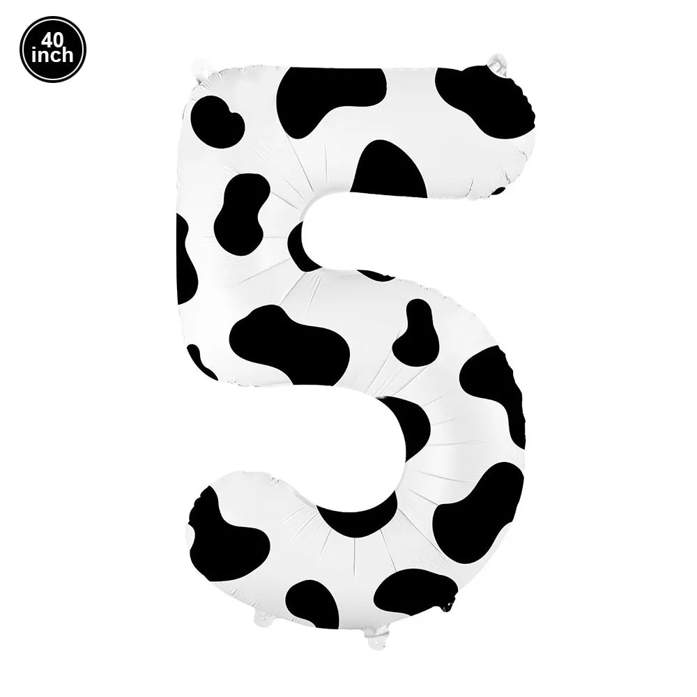 A large white foil balloon shaped like the number five with a black cow print pattern.