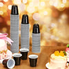 A display of black and white striped mini plastic shot cups for tastings and parties on a brown surface.